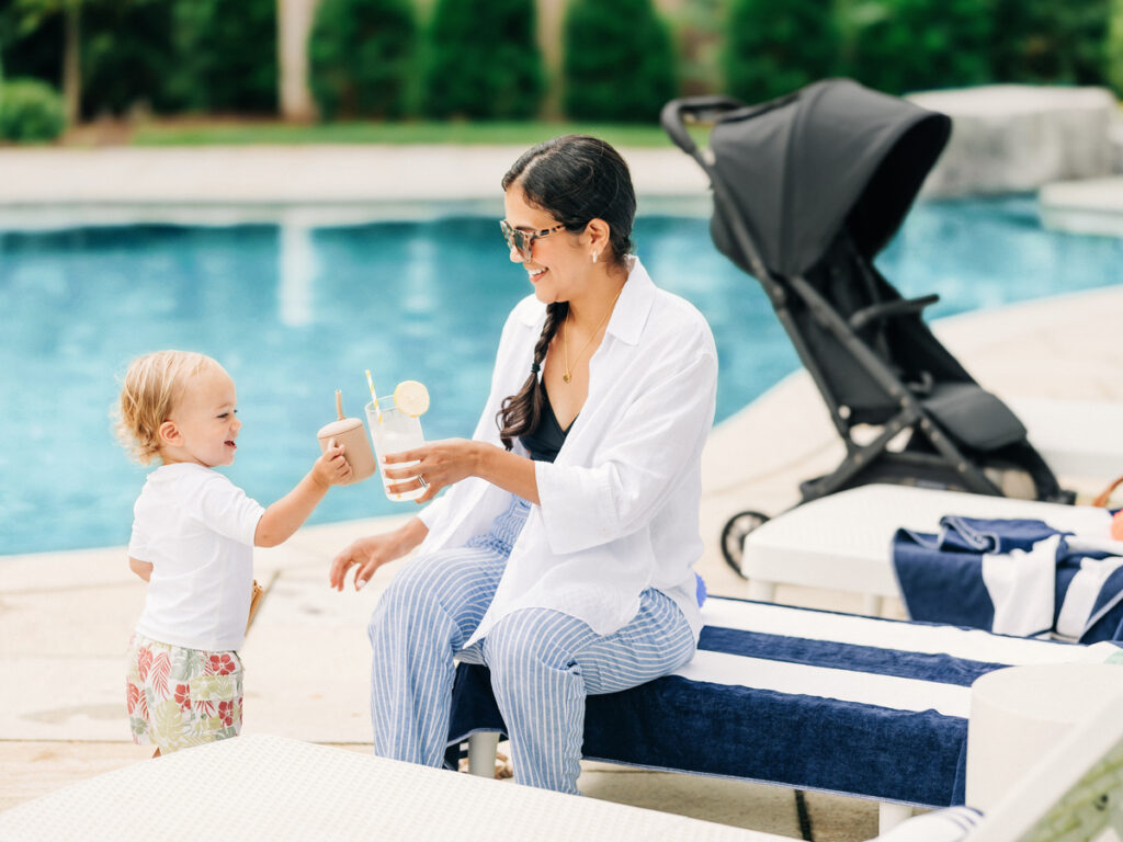 A woman and her child enjoy some refreshments by the pool, ready to get back to strolling in the Minu V2 travel stroller on a relaxing vacation